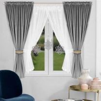 Zestaw dekoracyjny z zasłonami welurowymi, ozdobiony ażurowymi zawieszkami.